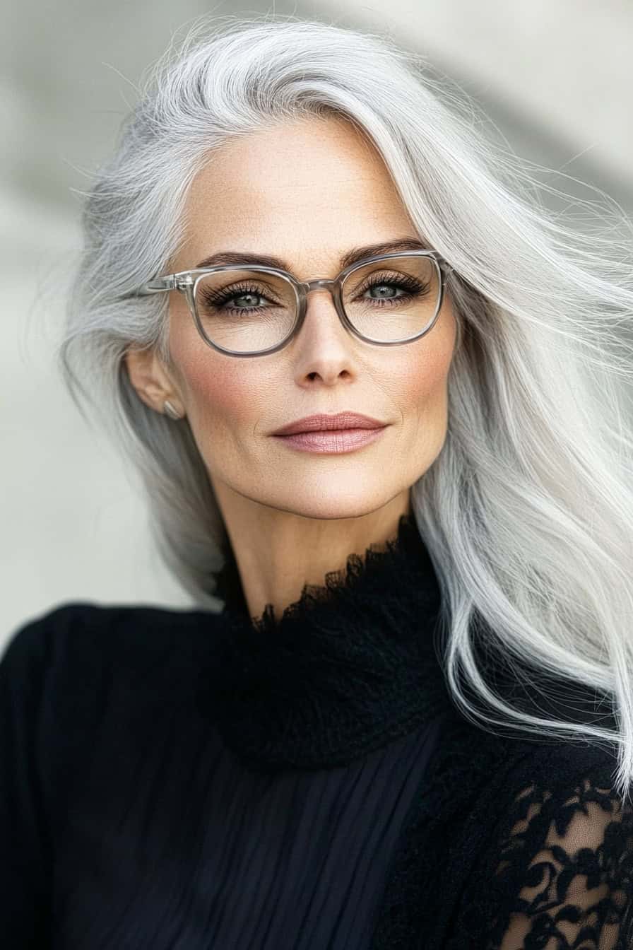 Woman with silver hair styled with subtle grey blending, creating a natural and elegant look that complements her glasses.