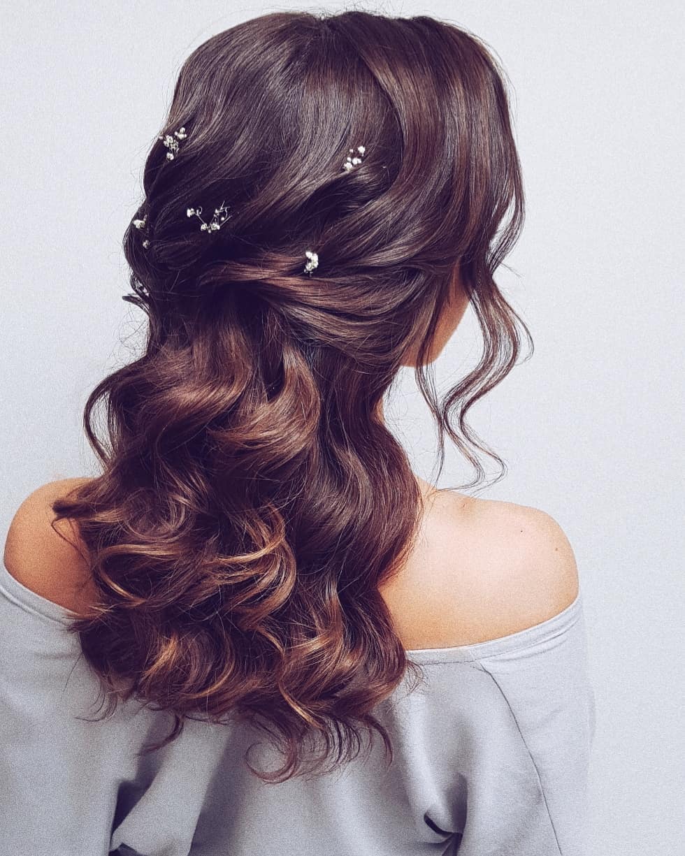 16-down-look Wavy hair worn down with multiple small, decorative accessories mixed in.