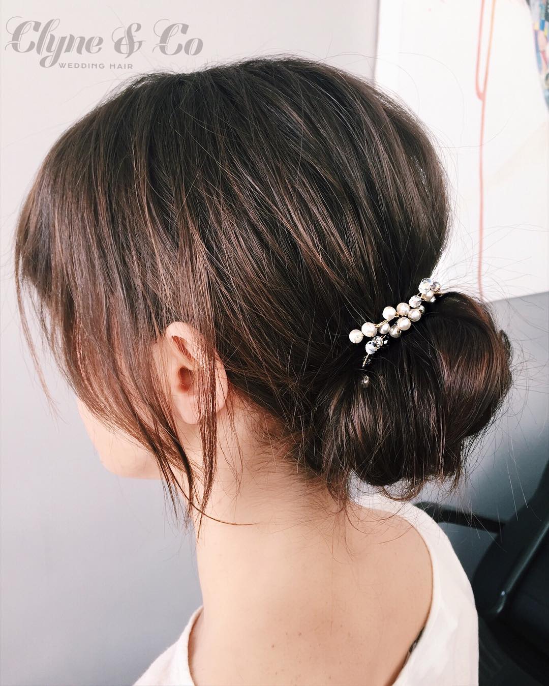 22-elegance A sleek low bun with a side part and a delicate hair accessory.