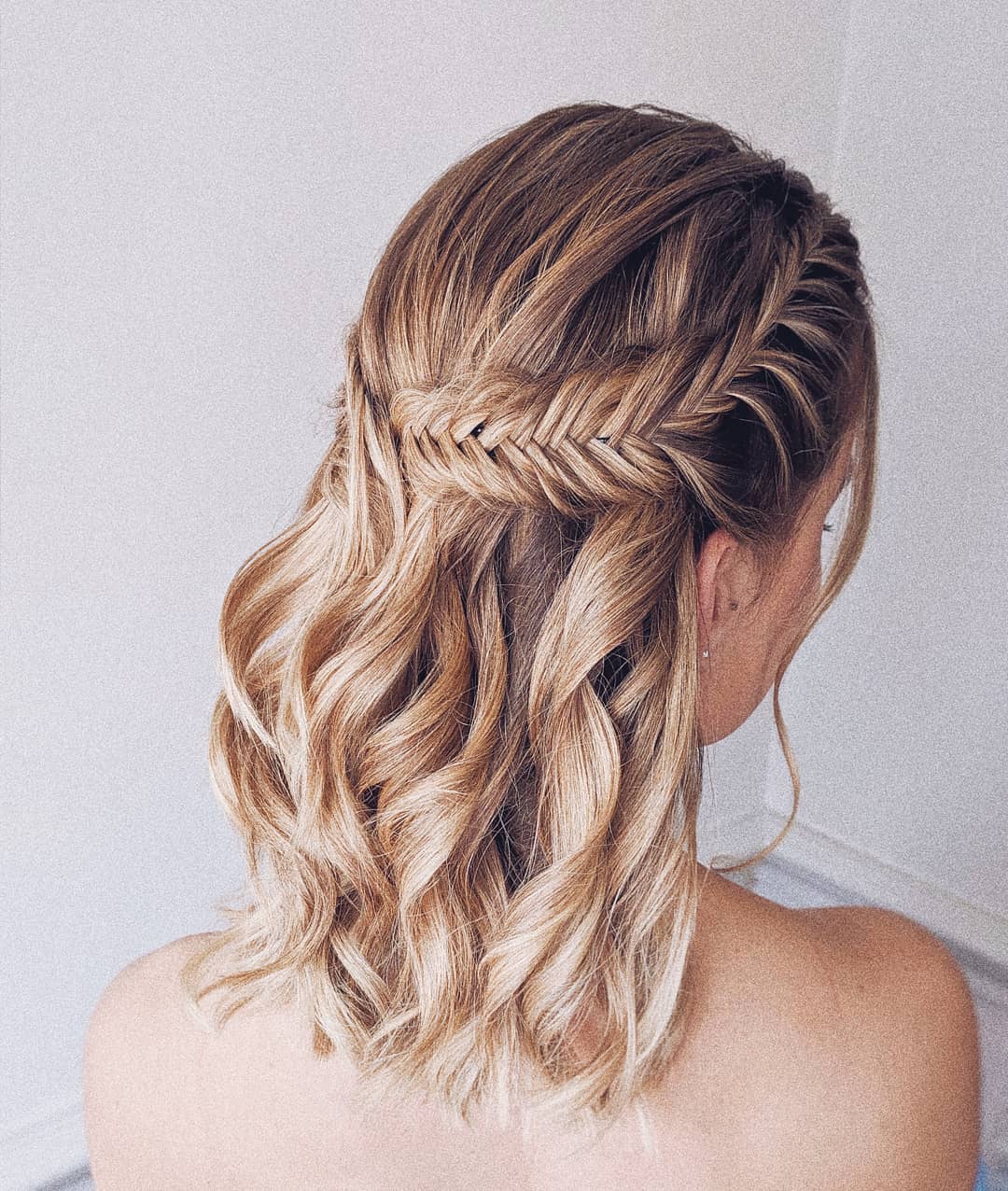 25-fishtail-braid A half-up style with a loose fishtail braid and wavy hair.