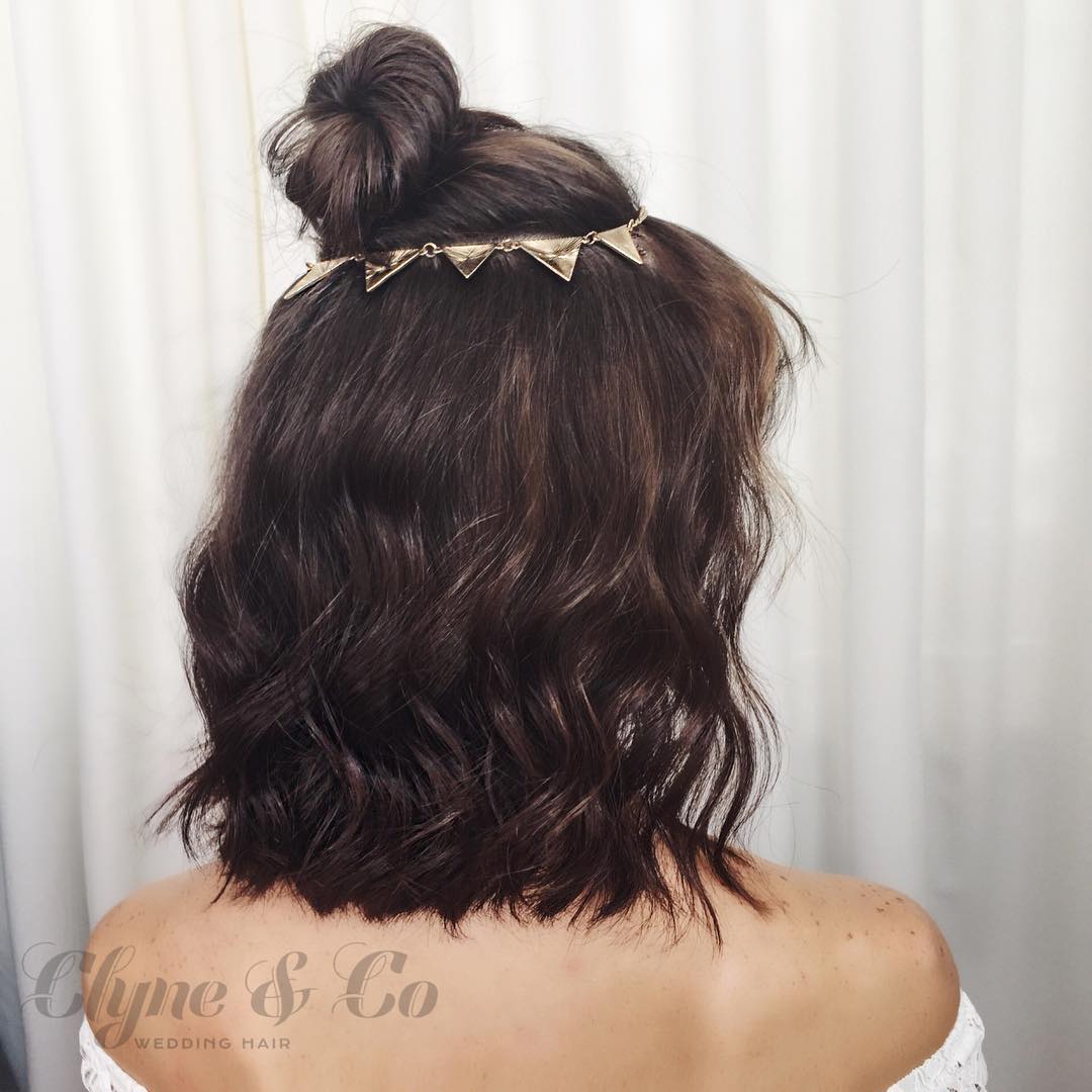 33-top-knot A high top knot with curled ends and a cool ring accessory at the base.