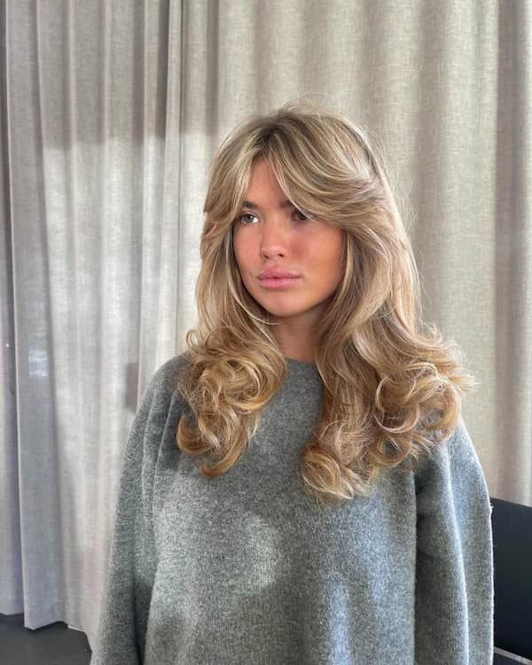 ash-blonde-voluminous-curly-hair-with-curtain-bangs Ash Blonde Voluminous Curly Hair with Curtain Bangs