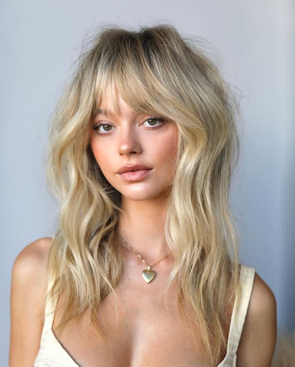 chic-blonde-wavy-haircut-with-layers-and-bangs Chic Blonde Wavy Haircut with Layers and Bangs