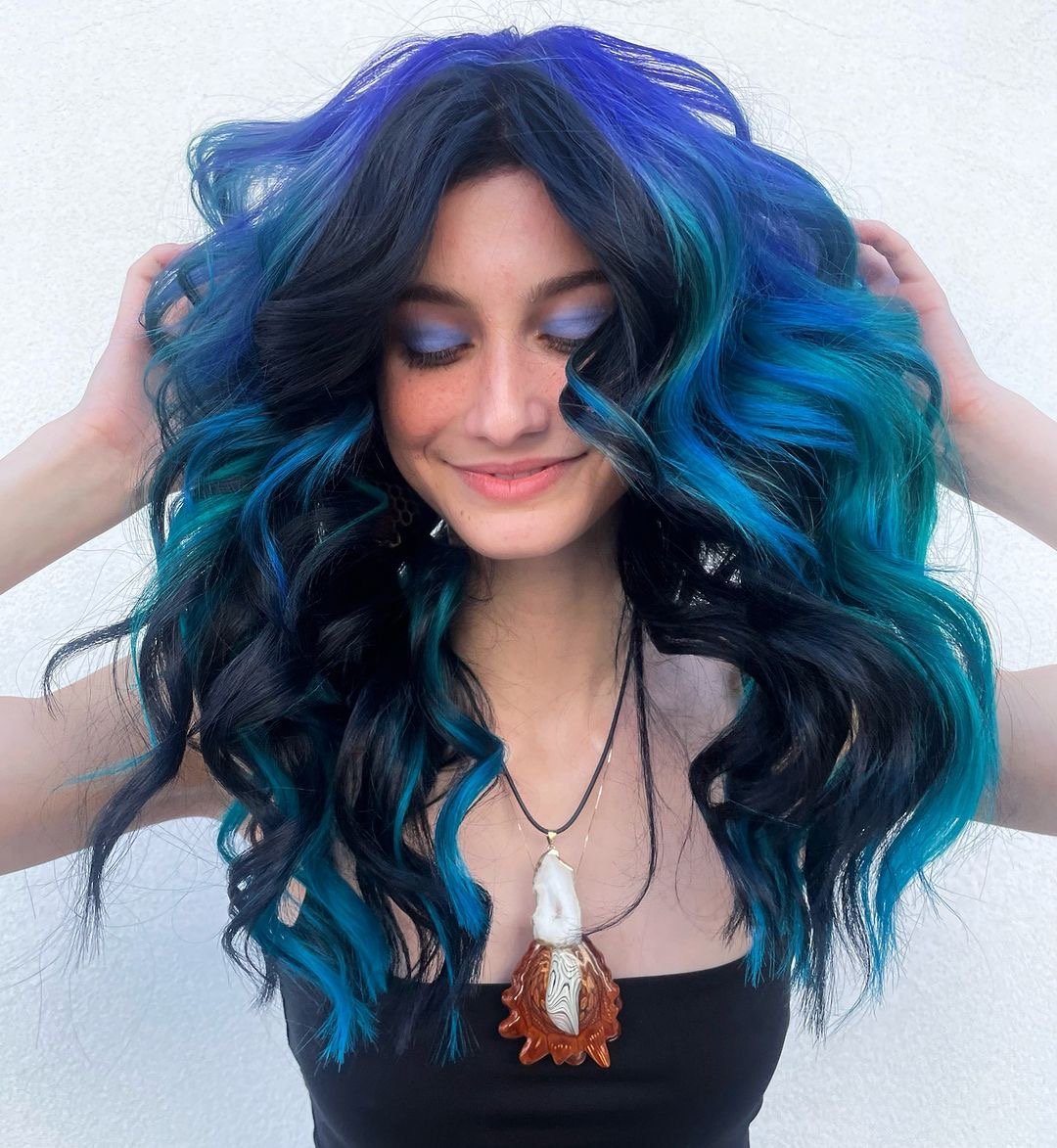 Beautiful blue and black hair color on long wavy hair.