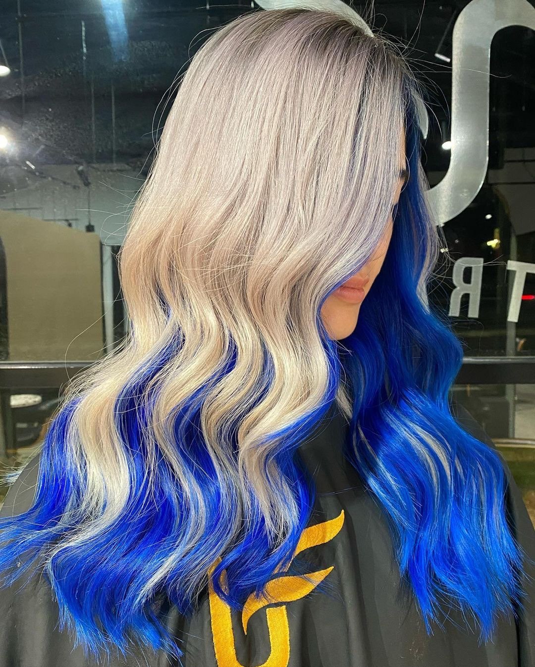 Gorgeous ash blonde and royal blue hair color on long wavy hair.