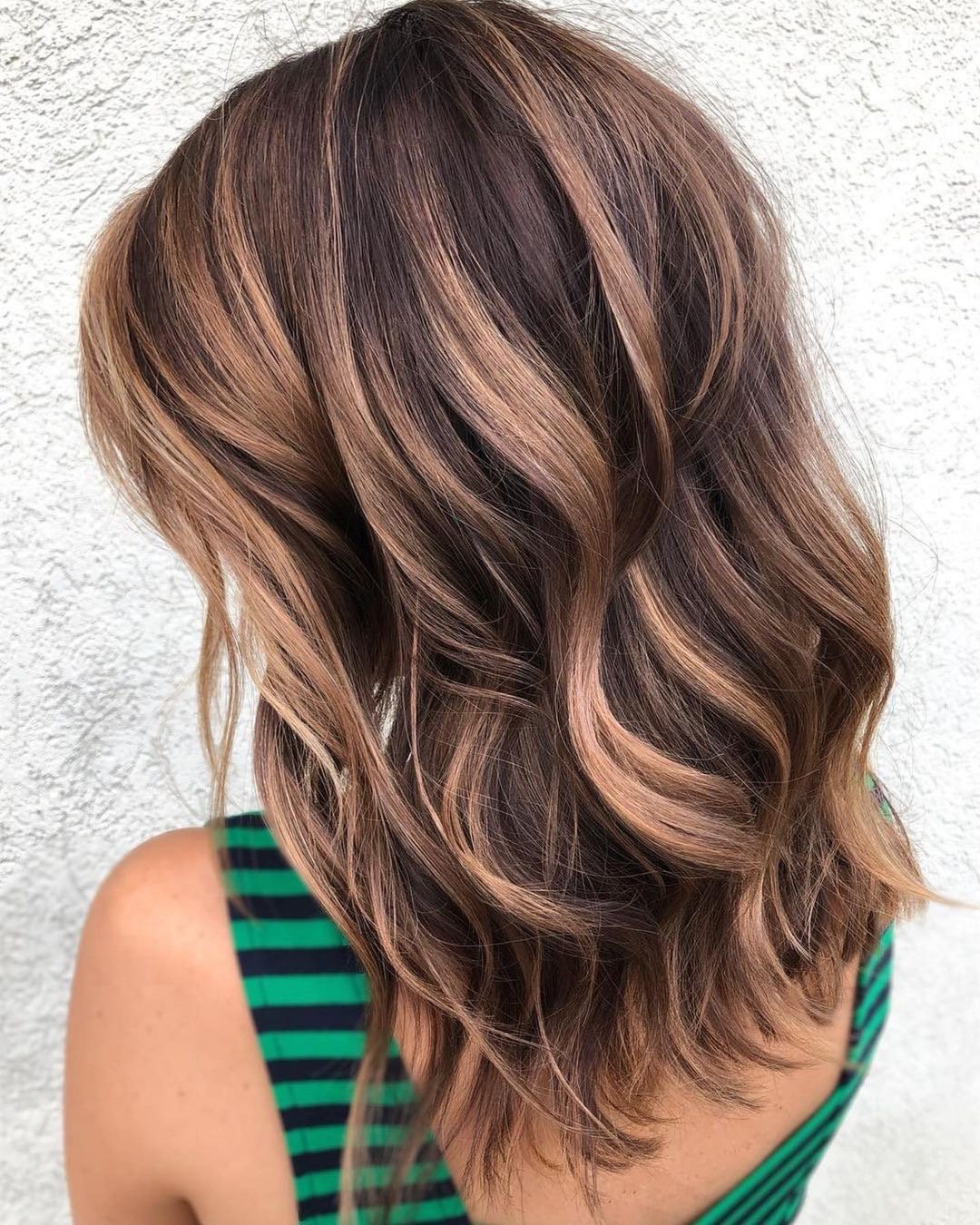 Beautiful caramel balayage on mid-length wavy hair.