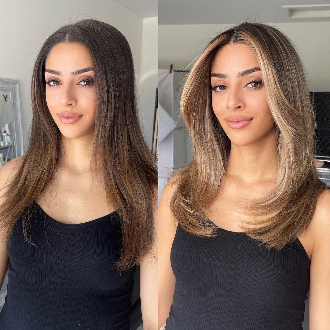 Woman with gorgeous long face framing layers and highlights.