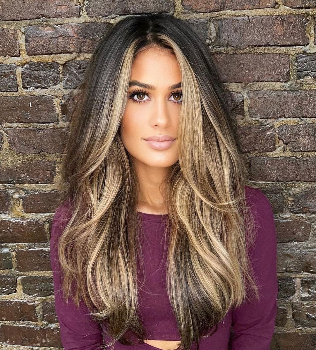 Woman with gorgeous long face framing layers and highlights.