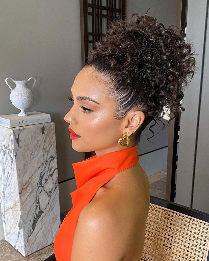 Woman with gorgeous pineapple bun on naturally curly hair. Find out what hairstyles are best for every hair type.