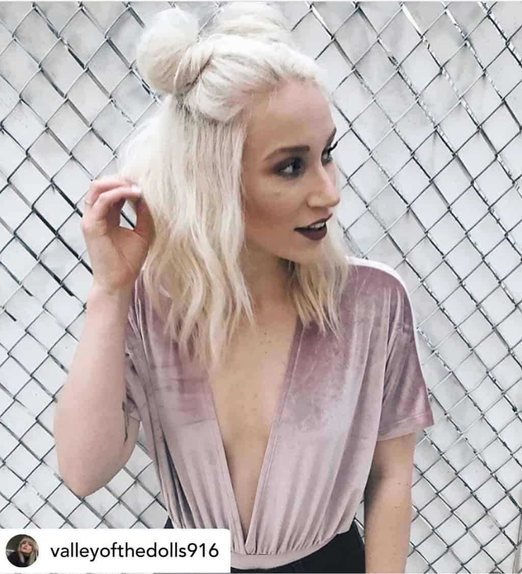 Woman with beautiful platinum blonde half-up space buns on medium-length hair.