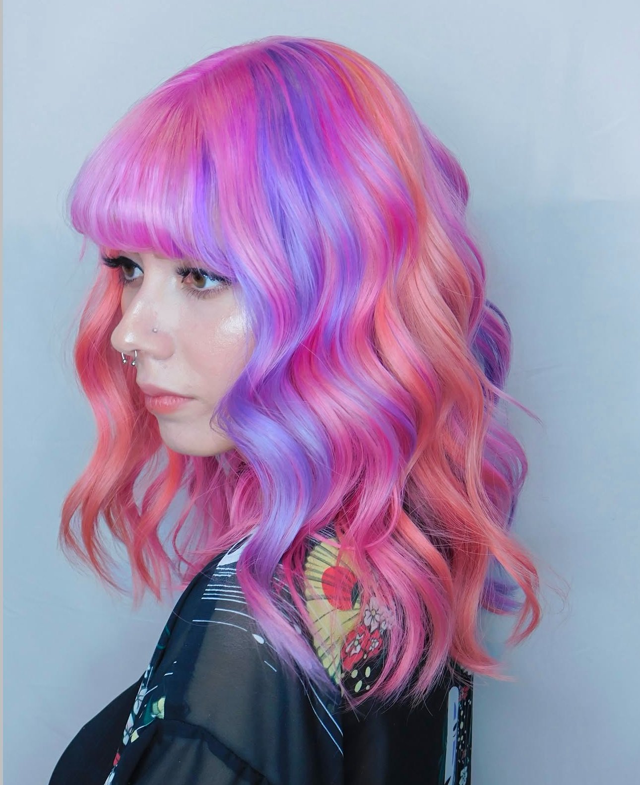 Beautiful woman with gorgeous pastel hair color on mid-length wavy hair.