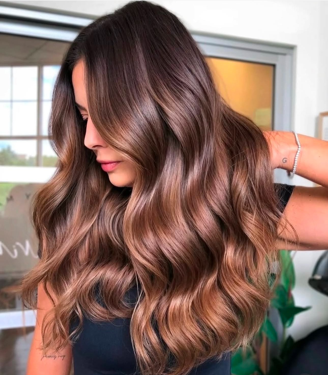 Beautiful woman with mocha mousse hair color on long wavy hair.