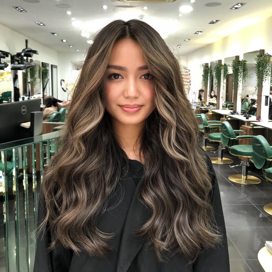 Gorgeous iced brunette hair color on long wavy hair.